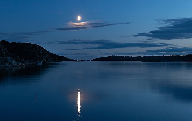 Waxing half-moon over water